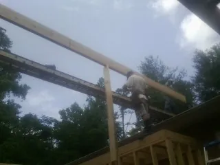 Carpenter setting a ridge beam over a new addition frame — Ice Dam Removal by Roofing Brothers in Grover